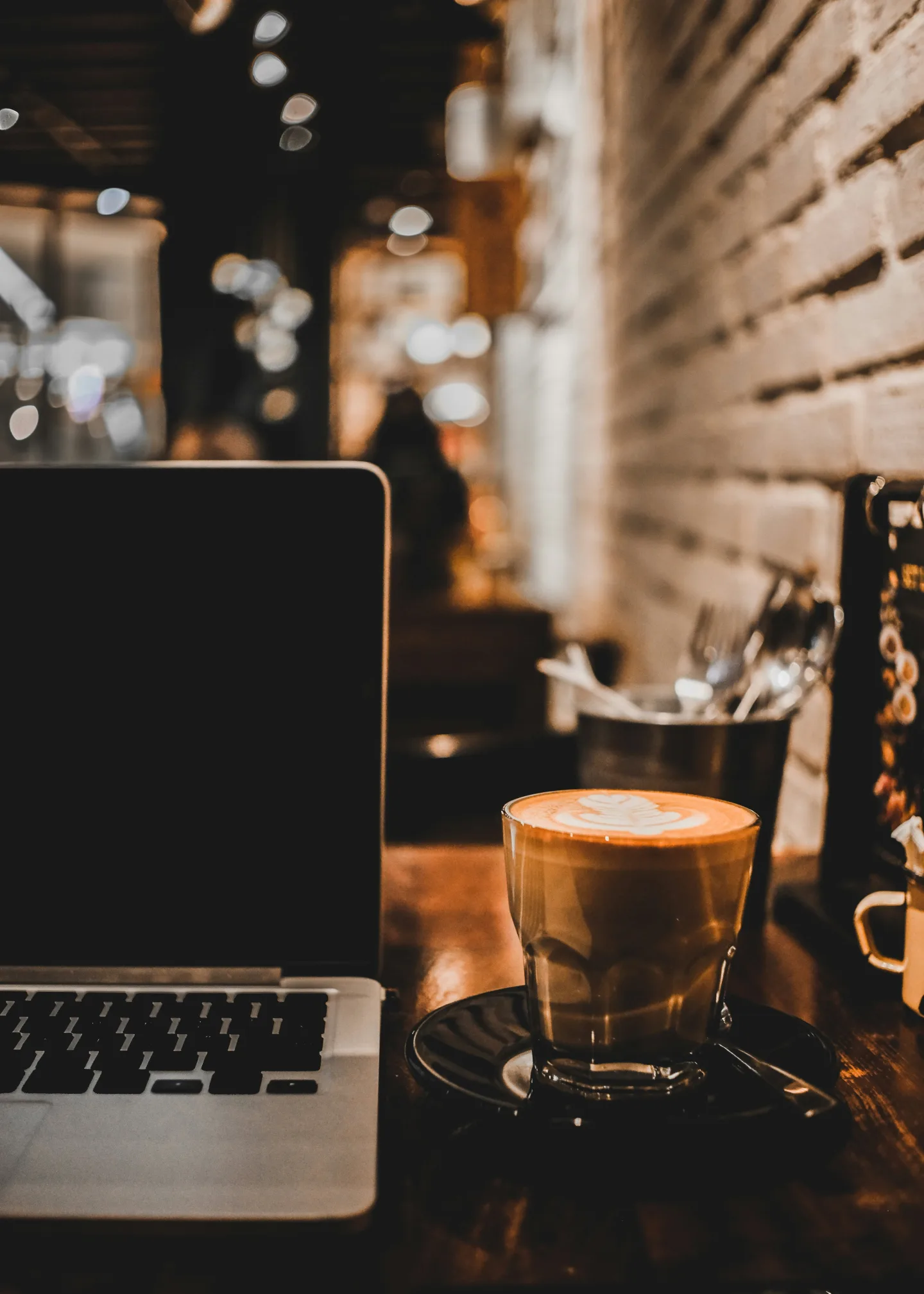 A laptop and coffee on a café counter, representing remote work in a noisy setting